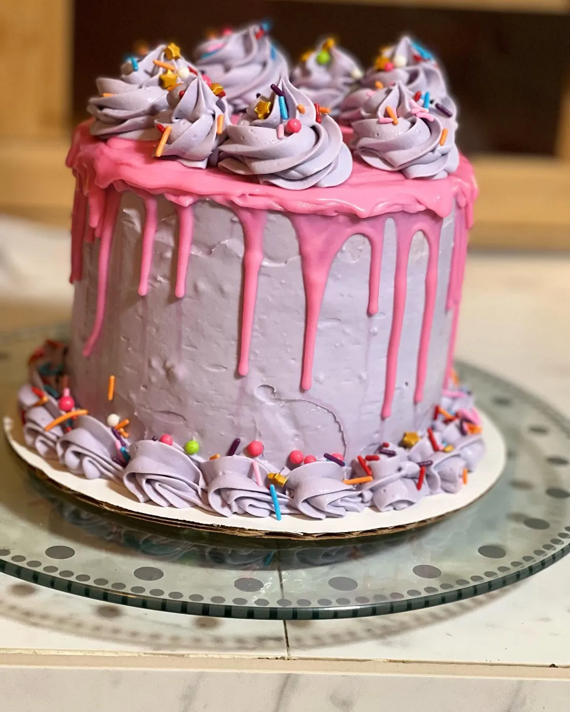 Purple buttercream drip cake with rainbow sprinkles