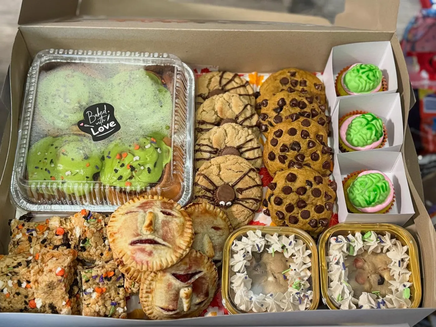 Horror Ghouls treat box packed with spooky-face hand pies, spider cookies, chocolate chip cookies, brain cupcakes and Halloween rice krispie bars